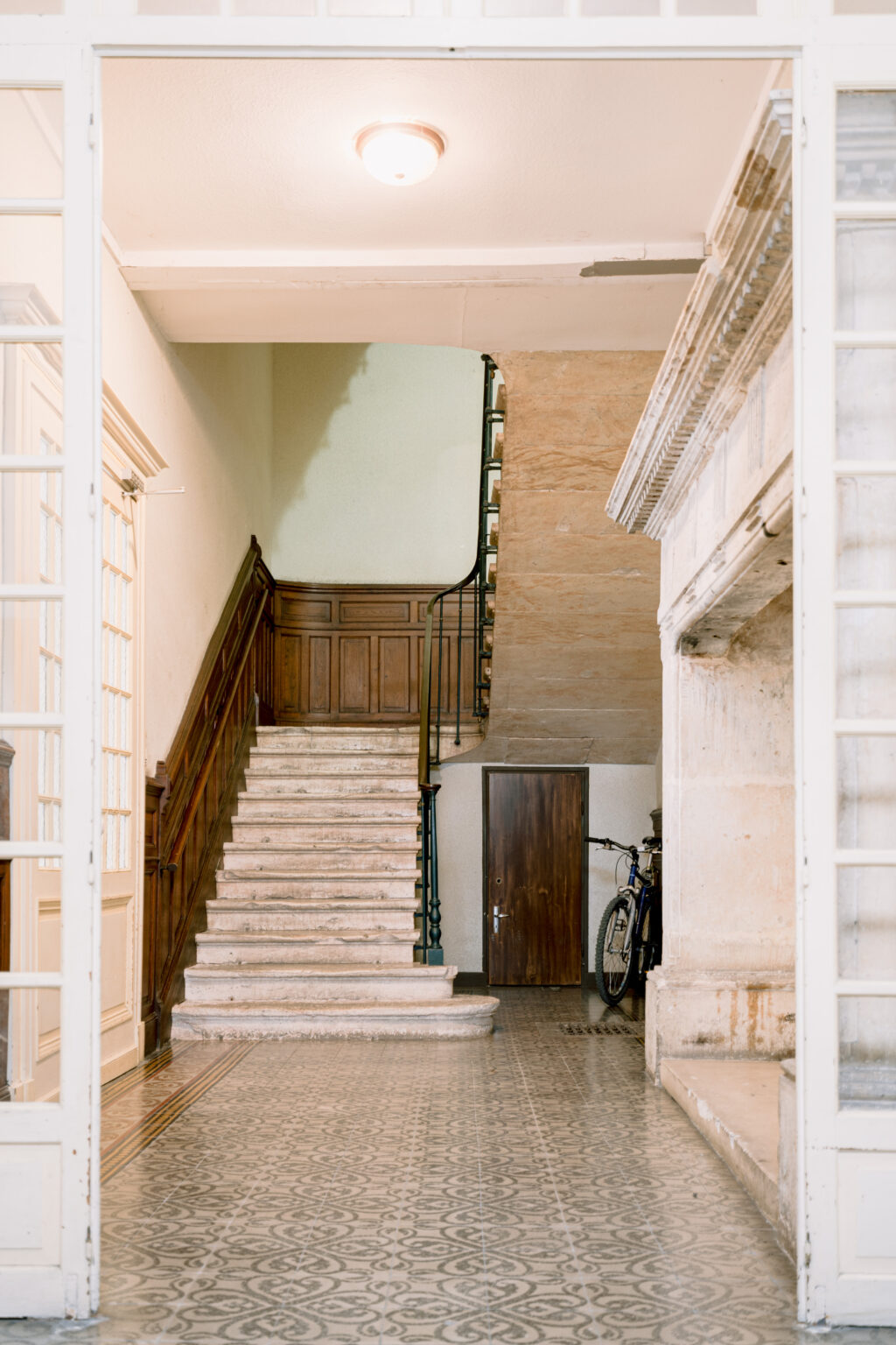 Vue charmante de l'ancien escalier en pierre d’époque ancienne, agrémenté de moulures en bois dans l’entrée intérieur. Un mariage authentique d'histoire et d'élégance.