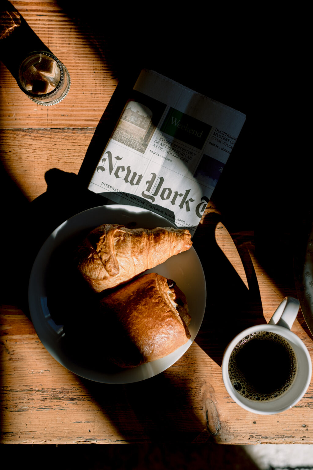 Délicieux petit-déjeuner avec croissant, chocolatine sur un journal Américain du New-York Times et une tasse de café